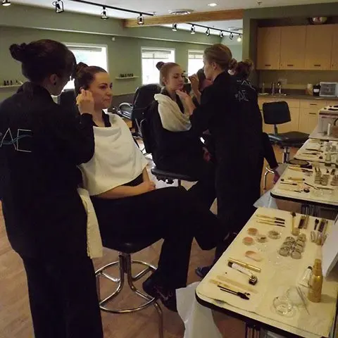 Several women in a salon, engaged in getting their hair styled, showcasing a vibrant and lively atmosphere.