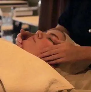A woman receives a soothing facial massage in a tranquil spa environment, promoting relaxation and rejuvenation.